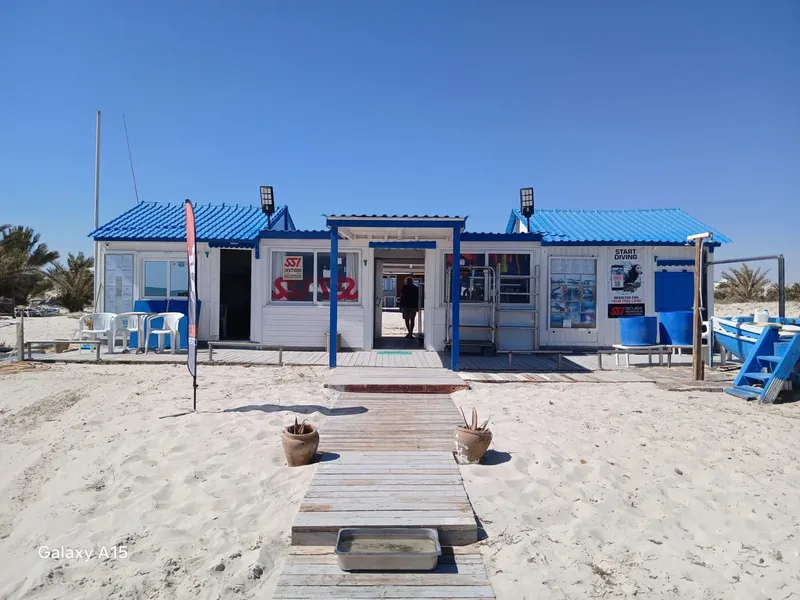 Façade d'un centre de plongée sur une plage de sable clair