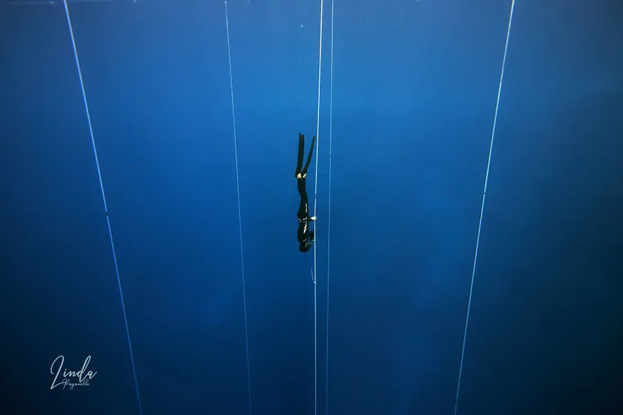 Apnée en profondeur : une plongeuse descend le long d'un câble vertical