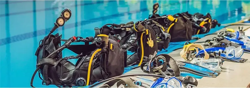 Equipement de plongée complet aligné au bord d'une piscine bleue claire