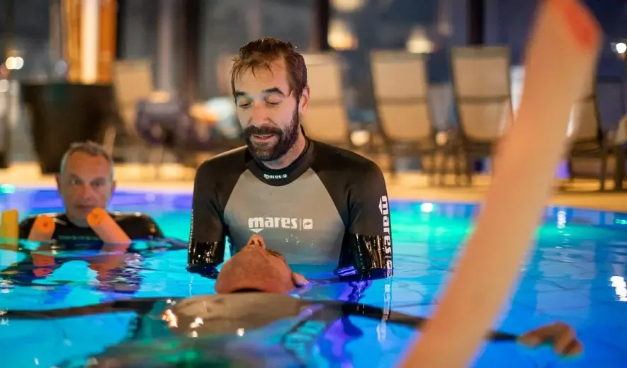 Instructeur de plongée en formation, assistant un élève dans une piscine
