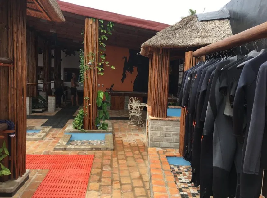Cour intérieure d'un centre de plongée avec des combinaisons et des personnes