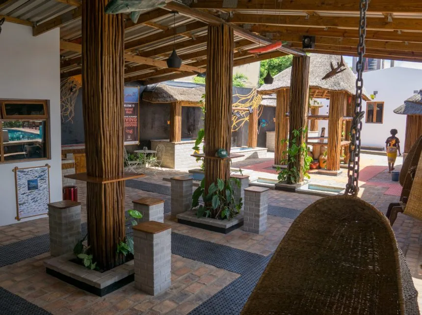 Espace détente extérieur avec mobilier en bois et végétation tropicale