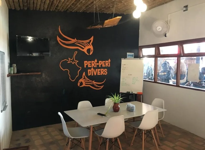 Intérieur d'un centre de plongée avec un mur décoré et des tables