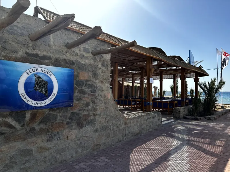 Façade d'un centre de plongée avec son logo et une structure ombragée