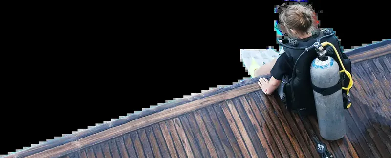 Plongeur s'équipant sur un ponton en bois avant une immersion