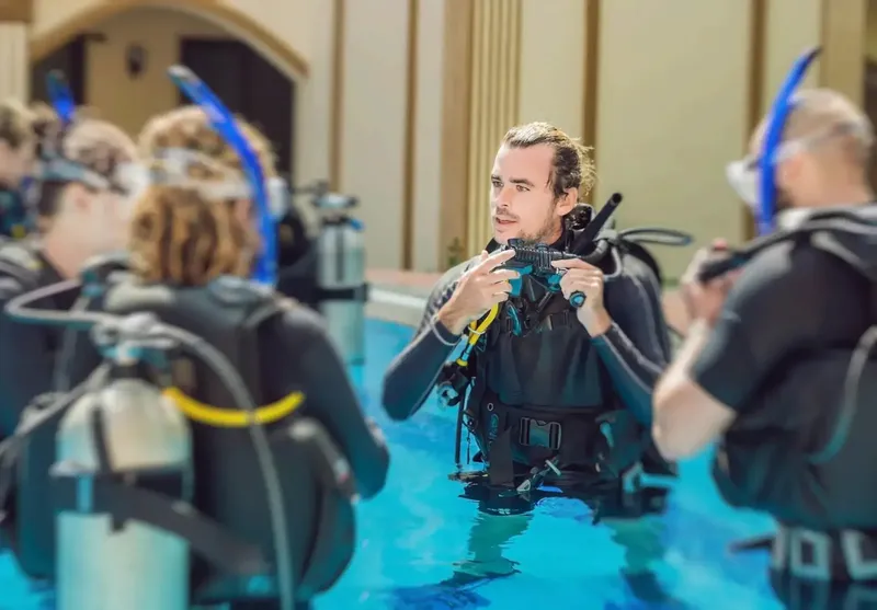 Formation plongée en piscine avec instructeur et participants équipés
