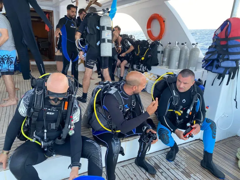 Plongeurs en combinaison sur le pont d'un bateau de plongée