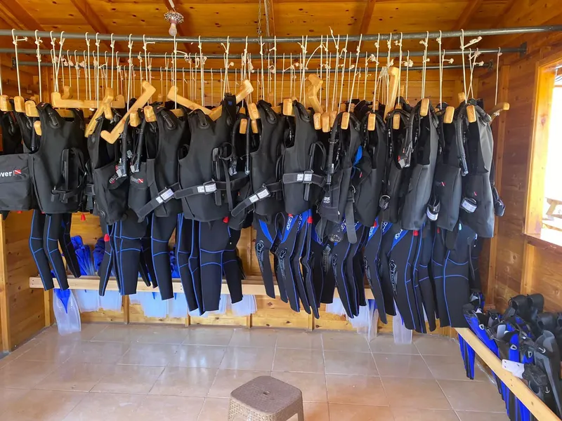 Rangées de combinaisons de plongée noires et bleues suspendues au plafond