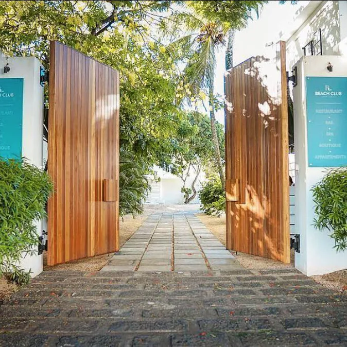 Entrée d'un club de plage avec deux grandes portes en bois ouvertes