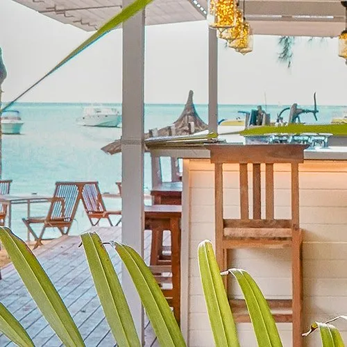 Terrasse en bois avec vue sur la mer et bateaux au loin