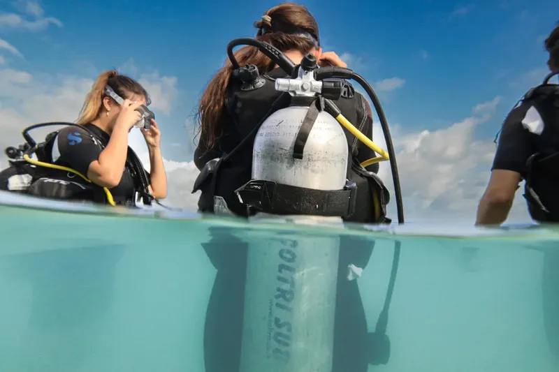 Plongeurs équipés se préparent à une immersion en milieu marin