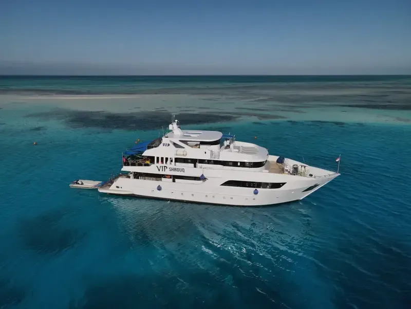 Grand yacht blanc naviguant sur une mer turquoise et calme