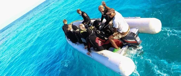 Groupe de plongeurs à bord d'un bateau pneumatique en mer