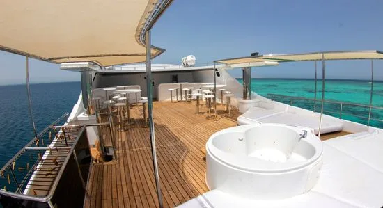 Terrasse d'un bateau de plongée avec jacuzzi et mobilier blanc