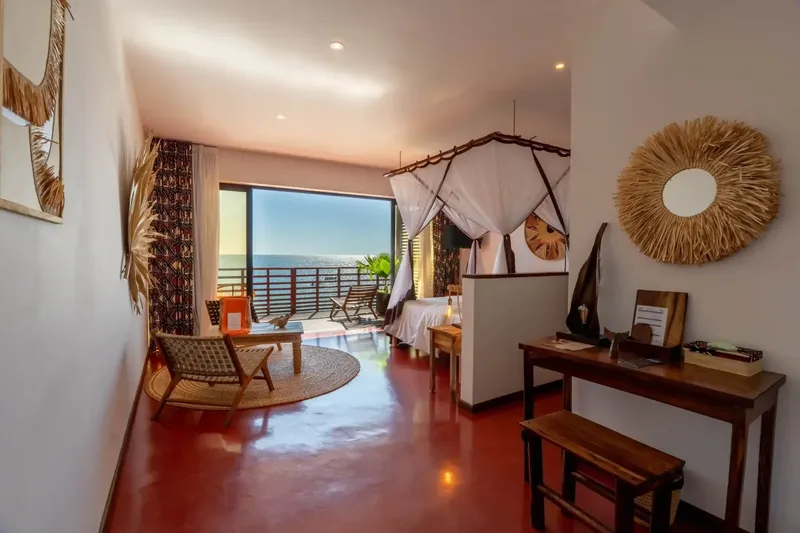 Chambre d'hôtel avec vue sur la mer, décoration ethnique et mobilier en bois