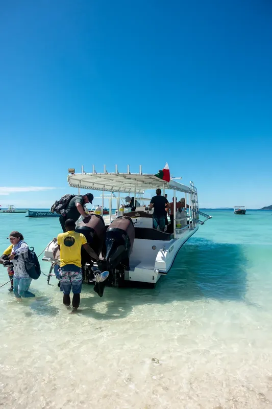 Plongée : des personnes montent à bord d'un bateau sur une plage