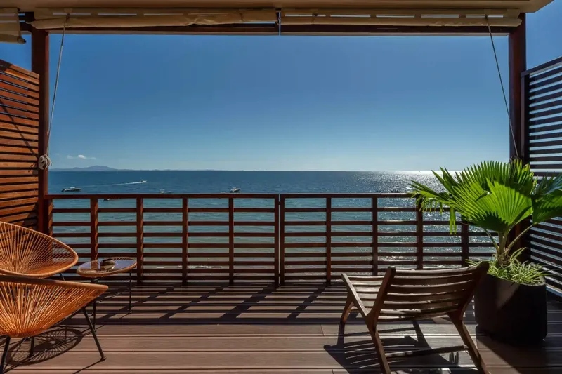 Terrasse en bois avec vue sur la mer et quelques bateaux