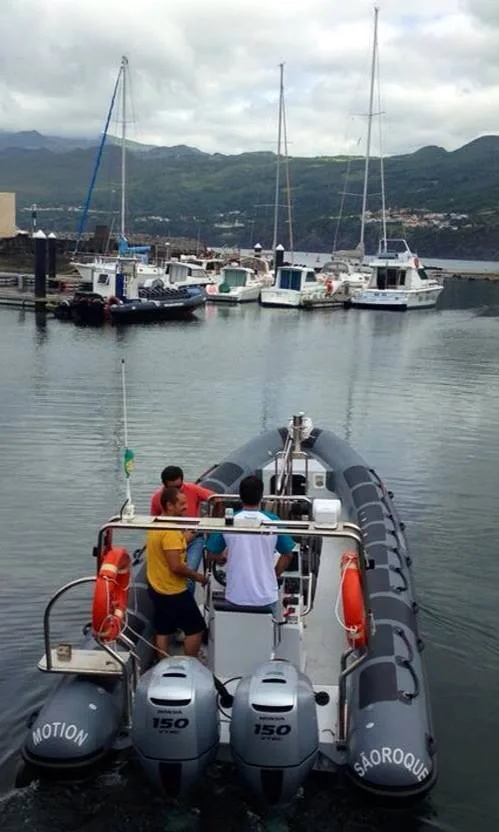 Personnes à bord d'un semi-rigide dans un port de plaisance ensoleillé
