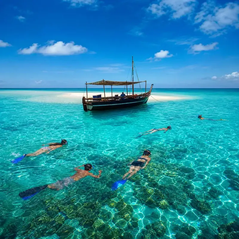 Plongée avec tuba dans une eau turquoise, bateau traditionnel en arrière-plan