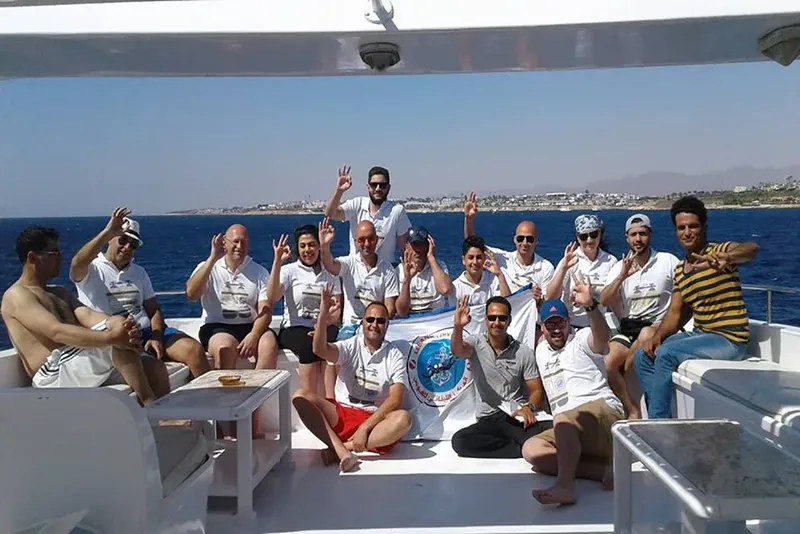 Groupe de personnes souriantes sur le pont d'un bateau en mer