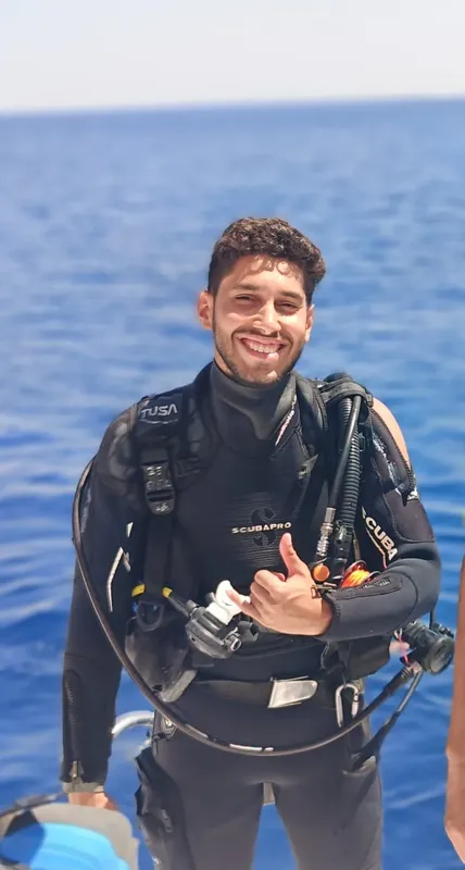 Plongeur souriant en combinaison, équipé, prêt pour une immersion