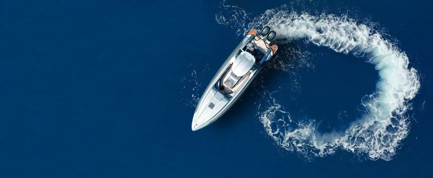 Bateau à moteur blanc naviguant sur une mer bleue calme