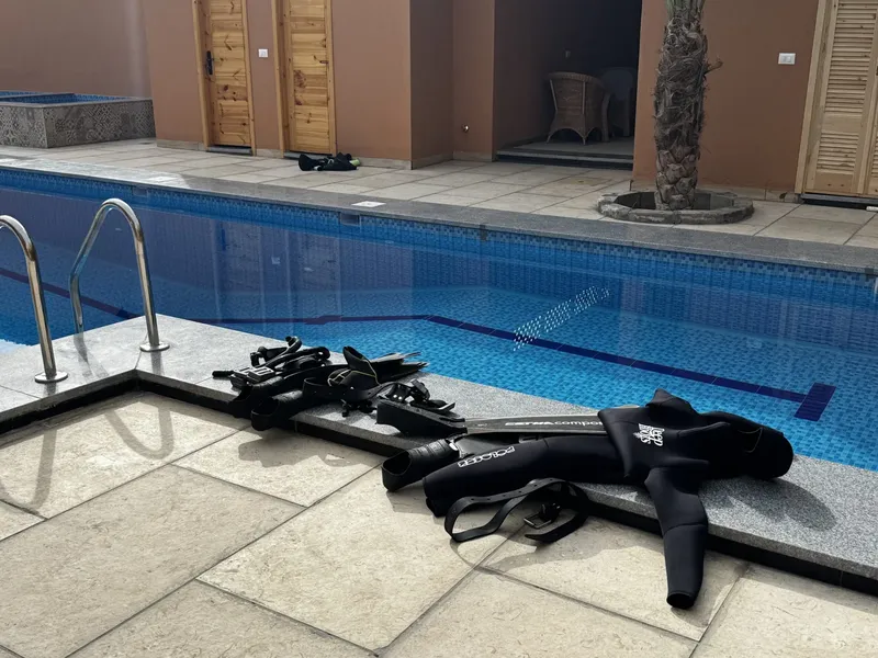 Equipement de plongée apnée près d'une piscine carrelée ensoleillée