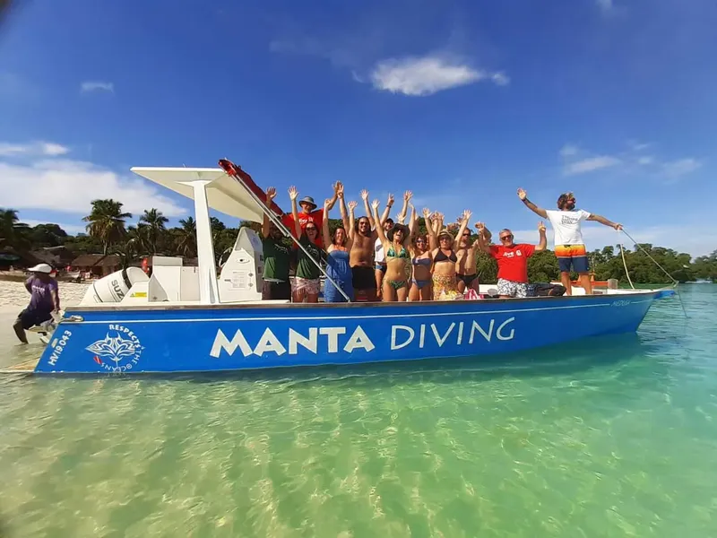 Groupe de personnes sur un bateau de plongée bleu et blanc