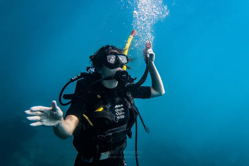 Plongeuse sous-marine avec équipement complet, bulles et lumière bleue