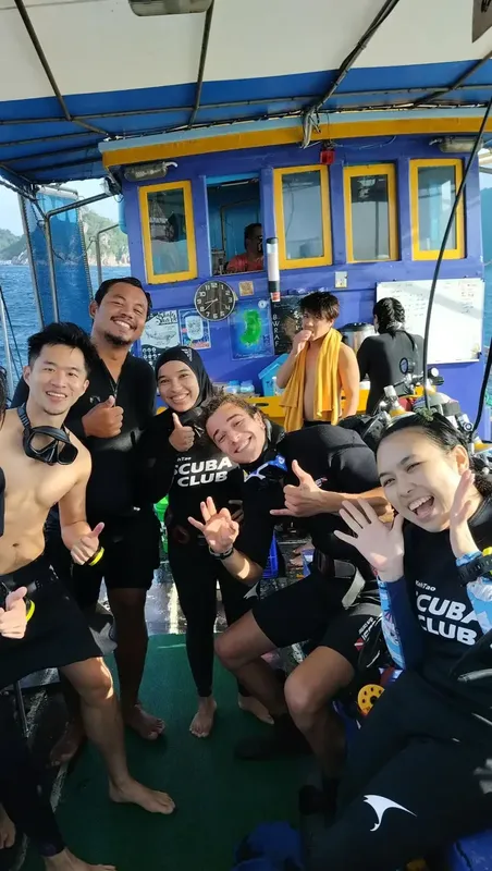 Groupe de plongeurs souriants sur un bateau de plongée en mer