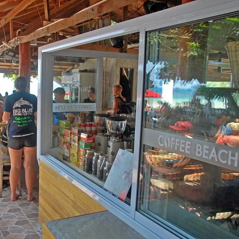 Vue d'un comptoir de café avec des personnes et un logo visible