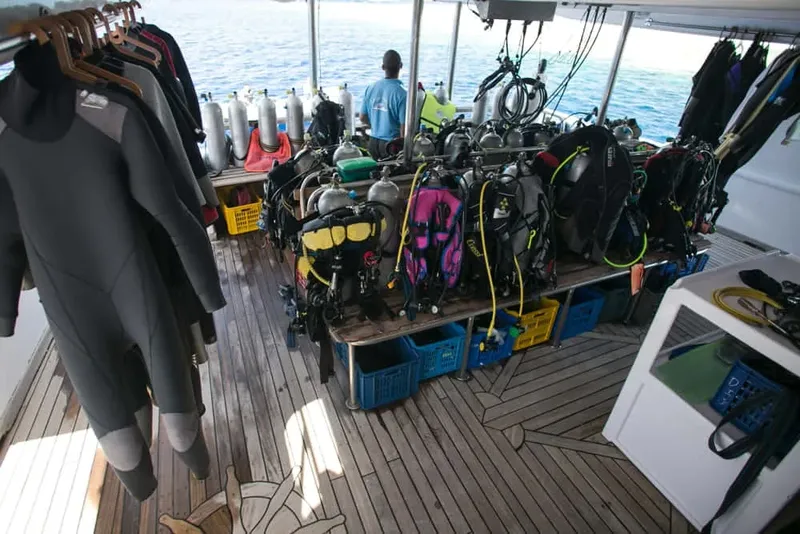Bateau de plongée avec combinaisons, bouteilles et plongeurs préparés