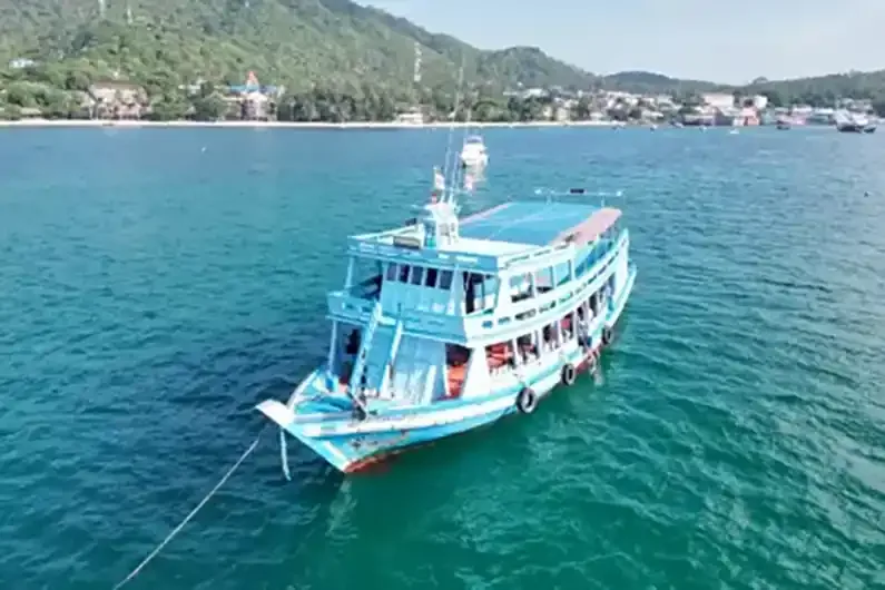 Bateau de plongée bleu et blanc en mer avec des personnes à bord