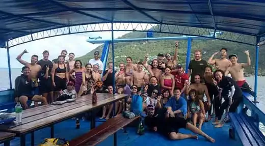 Groupe de plongeurs souriants posant sur le pont d'un bateau