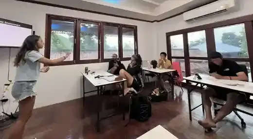 Cours de plongée en salle avec instructrice et participants attentifs