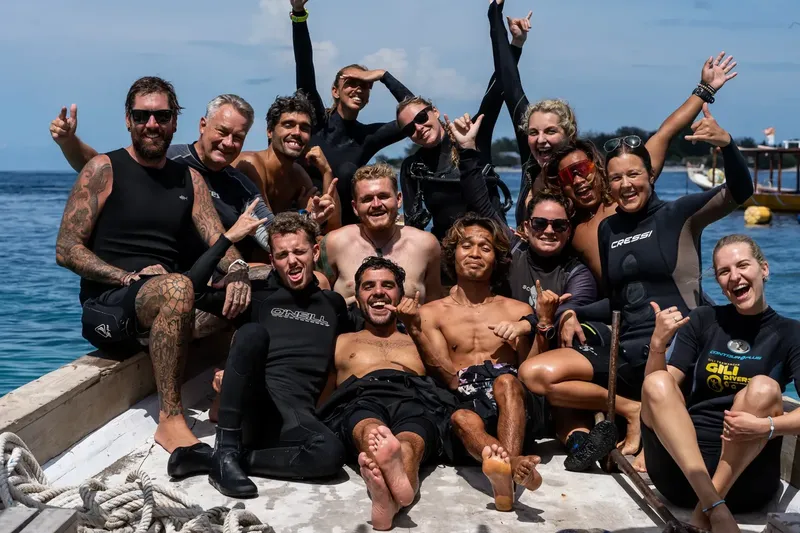 Groupe de plongeurs souriants à bord d'un bateau en mer