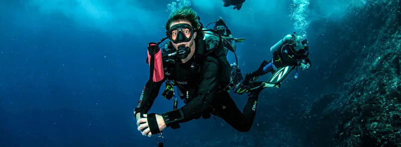 Plongeurs en combinaison explorent les profondeurs bleues de l'océan