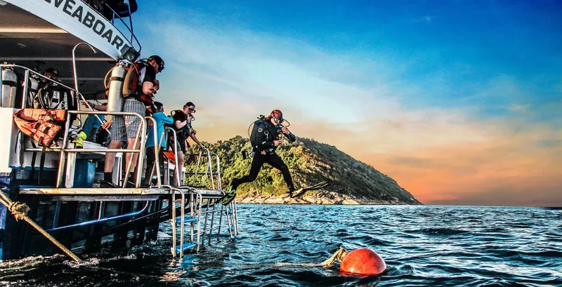 Plongeurs s'apprêtent à entrer dans l'eau depuis un bateau de plongée