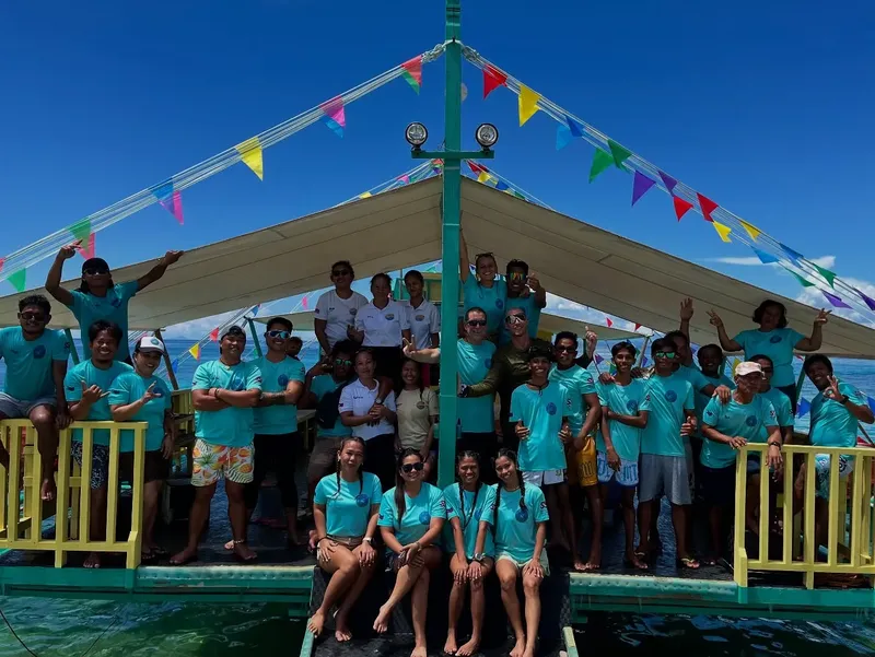 Groupe de personnes souriantes sur un bateau en mer ensoleillée