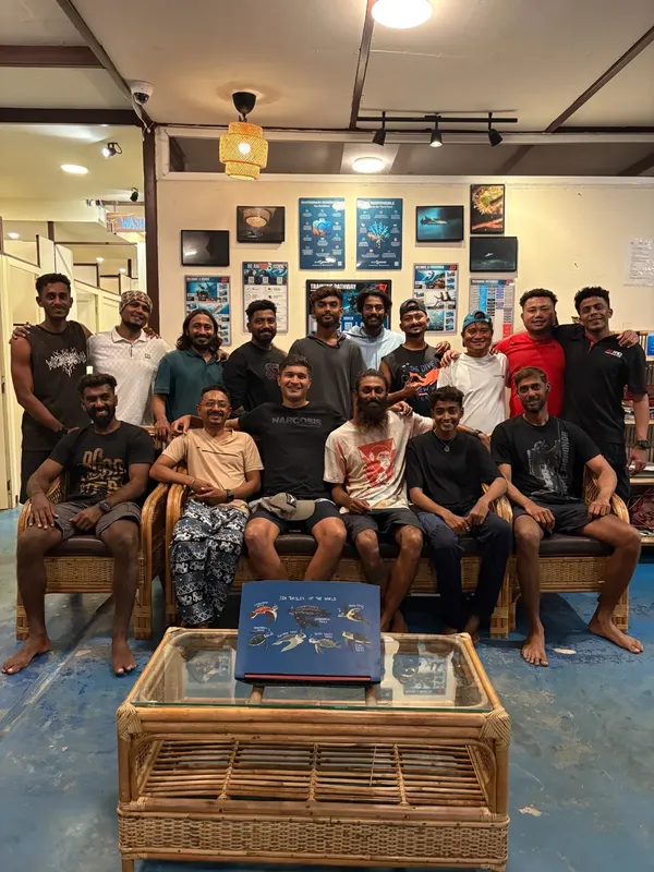Groupe de personnes souriantes posant dans un intérieur décoré de photos