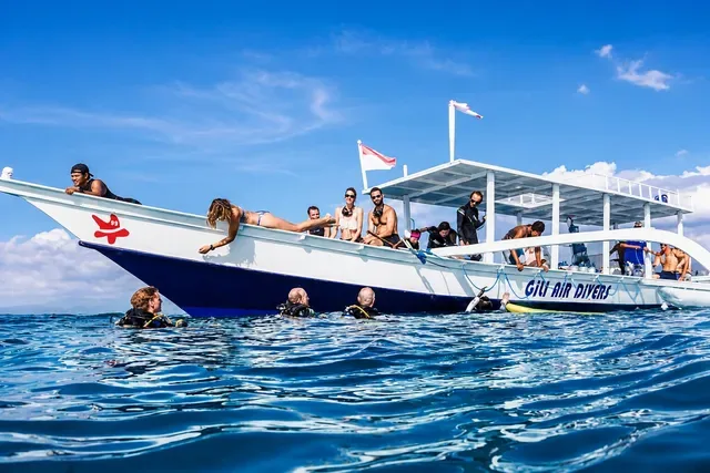 Plongeurs sur un bateau blanc en mer, préparation à une immersion