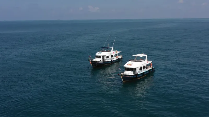 Deux bateaux de plongée naviguent sur une mer calme et bleue