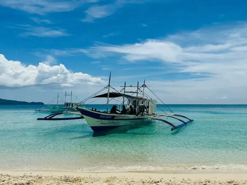 Bateau de pêche traditionnel amarré sur une plage de sable blanc