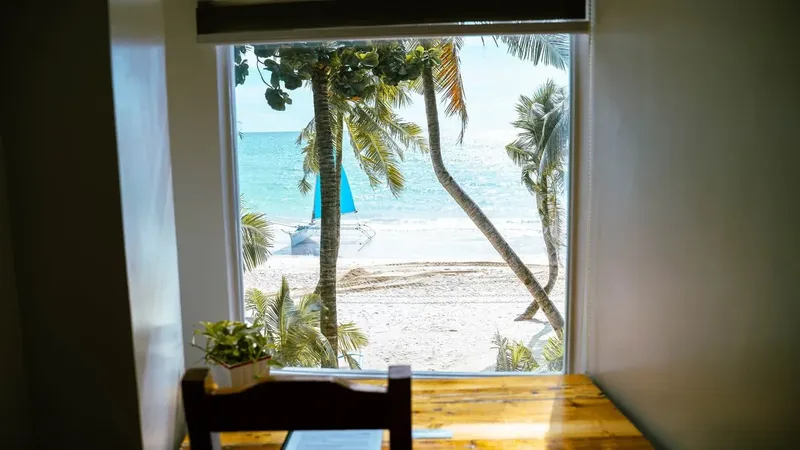 Vue sur une plage tropicale à travers une fenêtre ouverte
