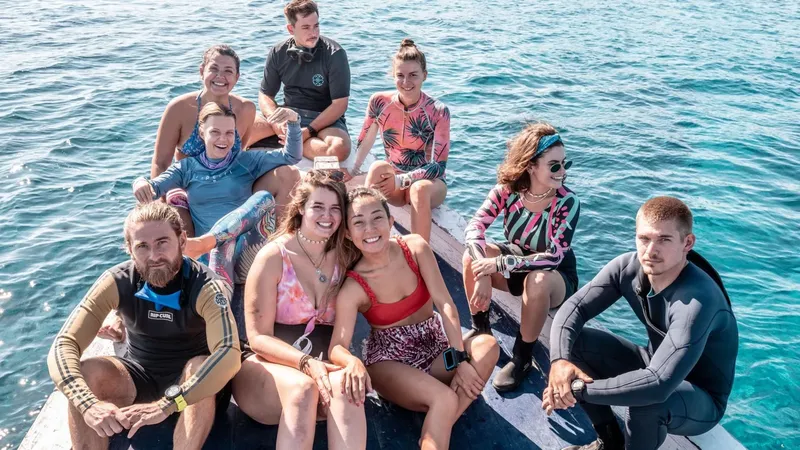 Groupe de personnes souriantes sur un bateau en mer, ambiance détendue