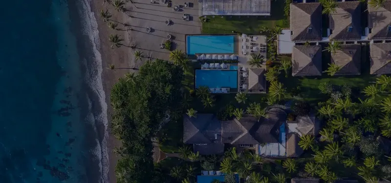 Vue aérienne d'un complexe hôtelier avec piscine et plage tropicale