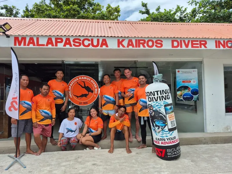 Groupe de personnes souriantes devant le centre de plongée Malapascua