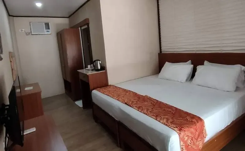 Chambre d'hôtel simple avec un lit double et une télévision