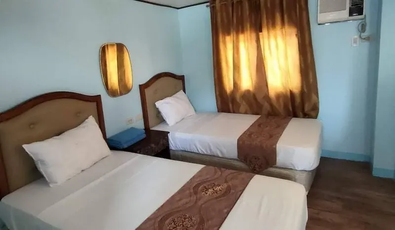 Chambre d'hôtel avec deux lits simples, décoration simple et climatisation