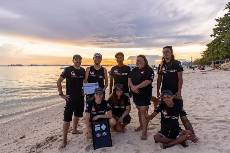 Groupe de personnes souriantes sur une plage au coucher du soleil